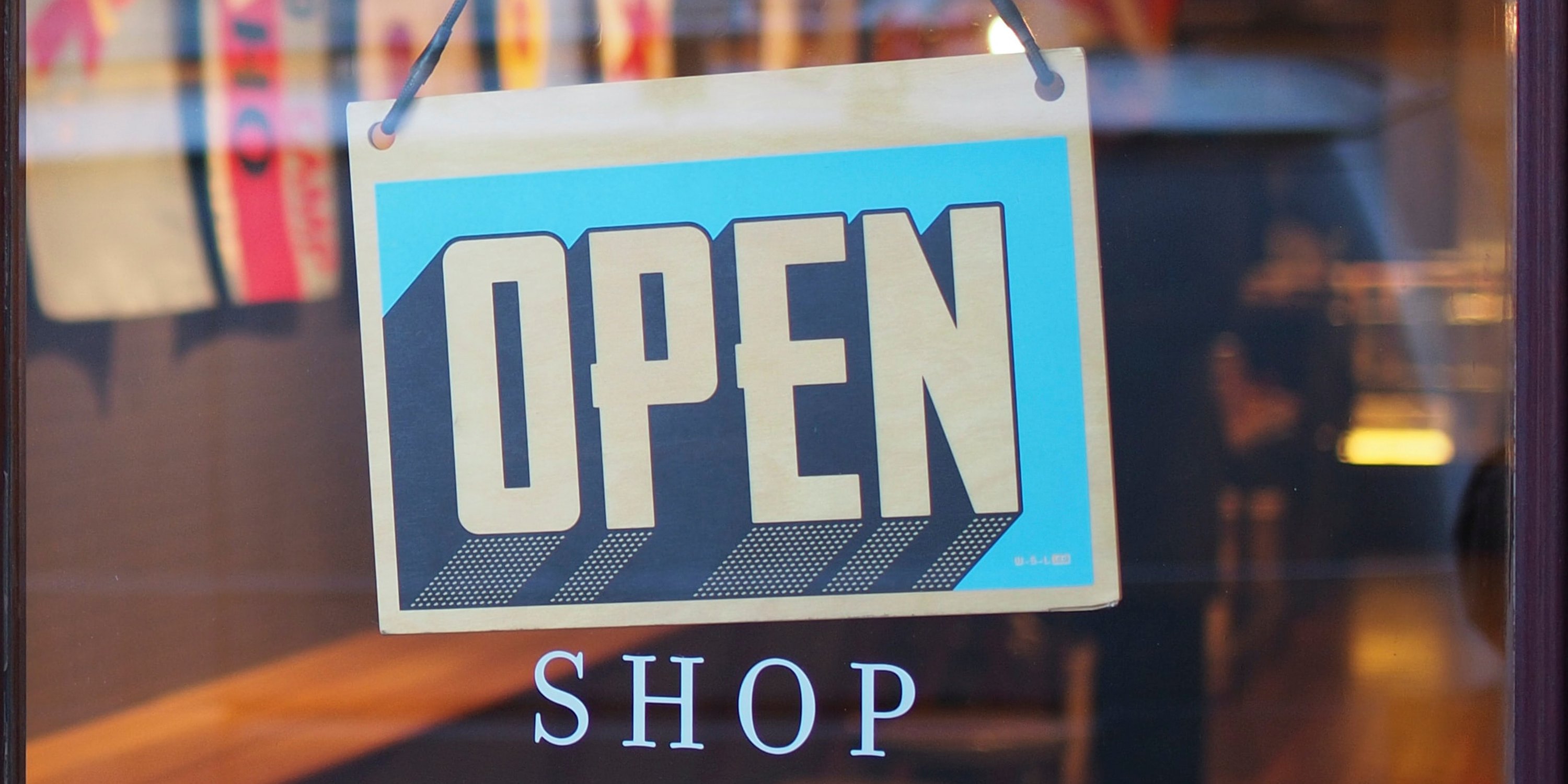 Close up of 'Open' sign in shop's glass door